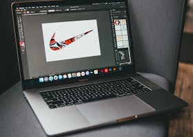 From above of modern netbook with working graphic program located on gray couch in room