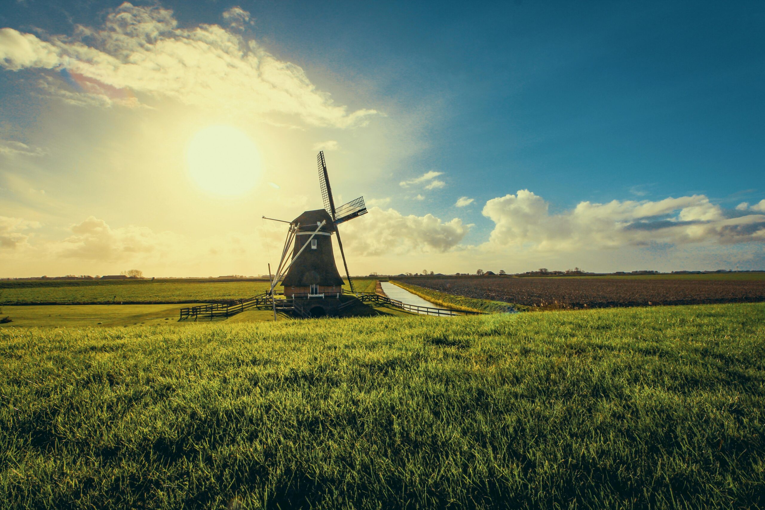 Beautiful windmill in Uithuizermeeden, Netherlands, surrounded by fields at sunset.